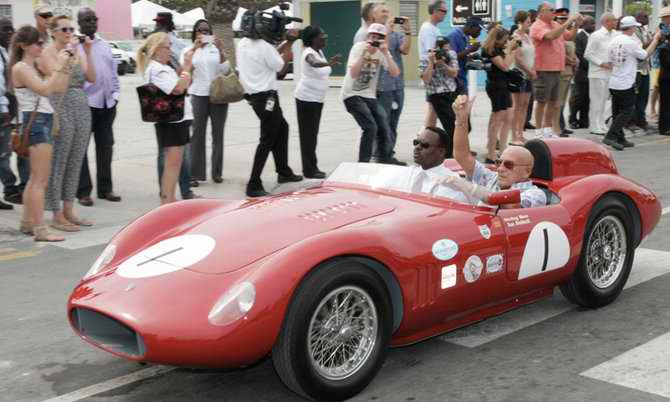 Minister of Youth, Sports and Culture Daniel Johnson (left) and Sterling Moss (right) drives off in Sterling Moss’s car at the opening of Speed Week 2012 at Arawak Cay yesterday&nbsp;morning.